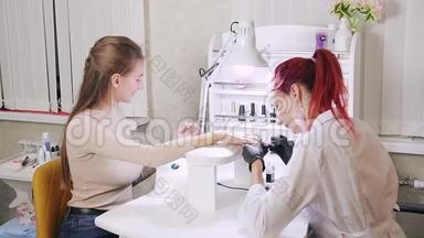 美容院的女美甲师在顾客的指甲上涂上了彩色凝胶<strong>抛光</strong>剂
